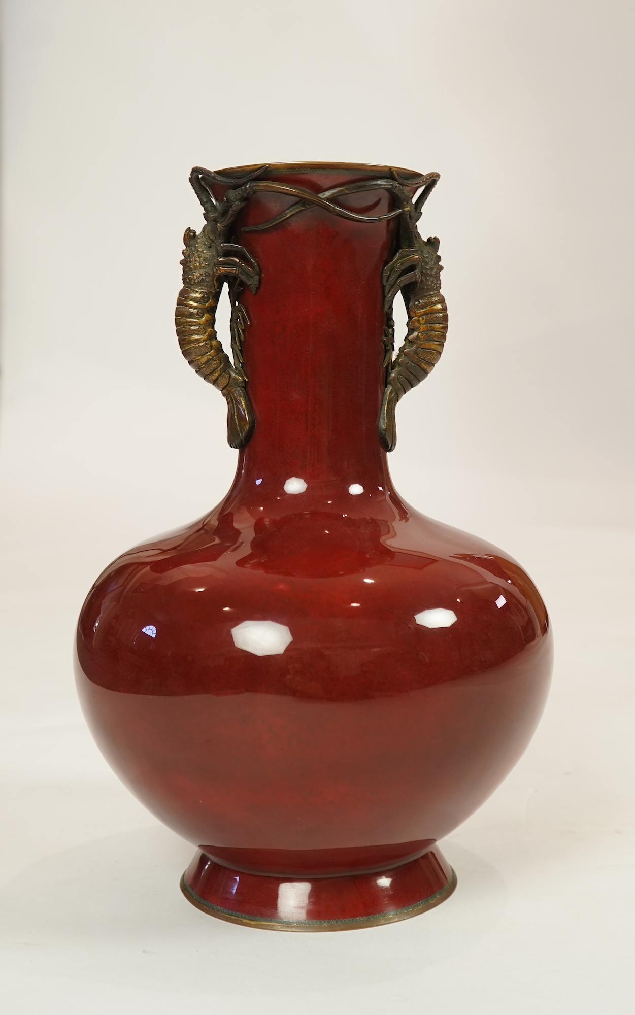 An unusual Japanese sang-de-boeuf ground cloisonné enamel and gilt metal mounted vase